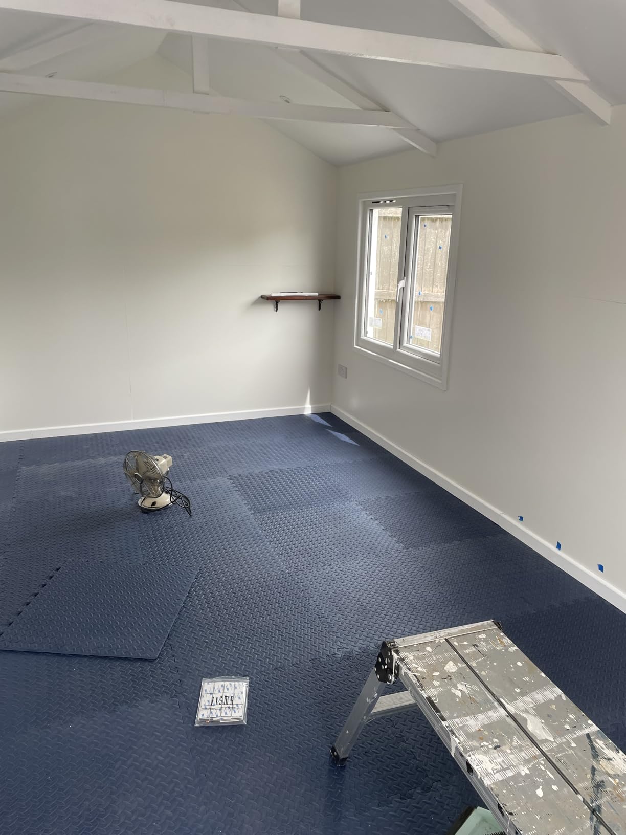 Blue 60×60 interlocking EVA gym flooring tiles covering a garden studio floor