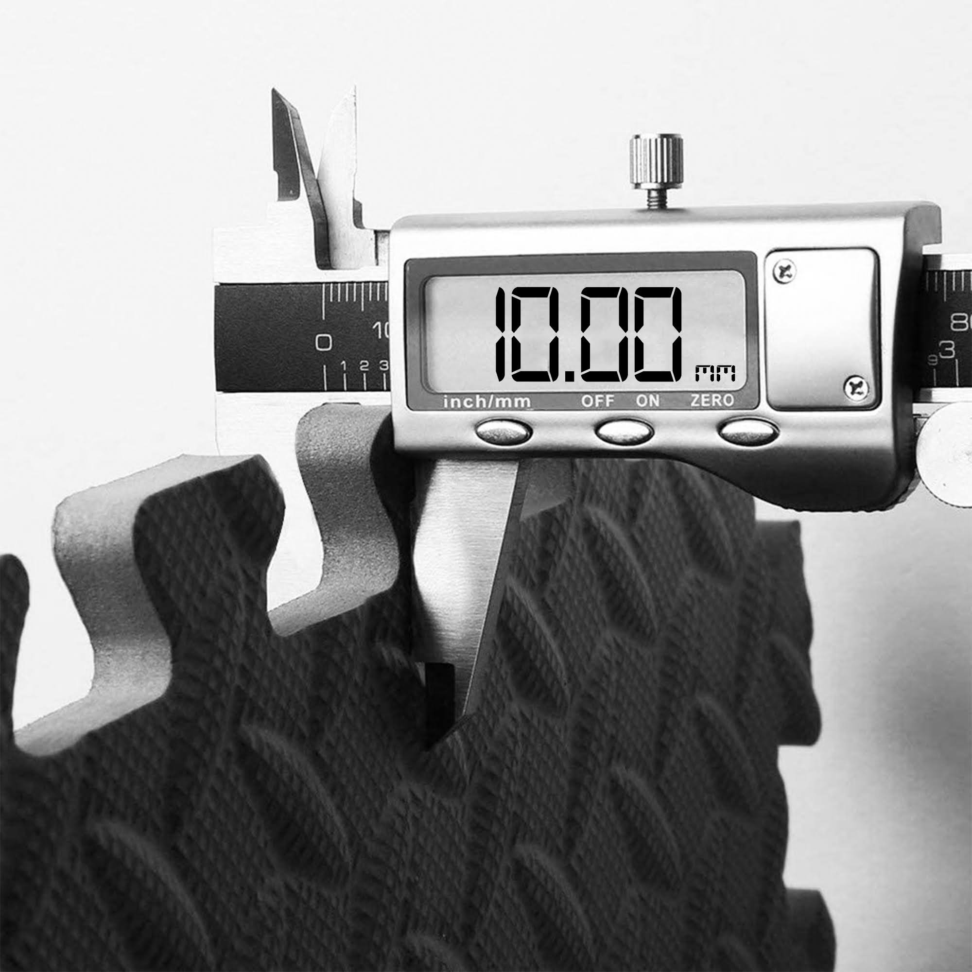 Digital caliper measuring 10 mm thickness on a ComFy yoga mat